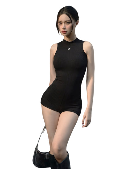 Woman wearing a black sleeveless bodysuit on a white background