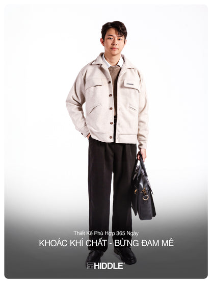 Man wearing a white jacket and black pants holding a bag on a white background with text.