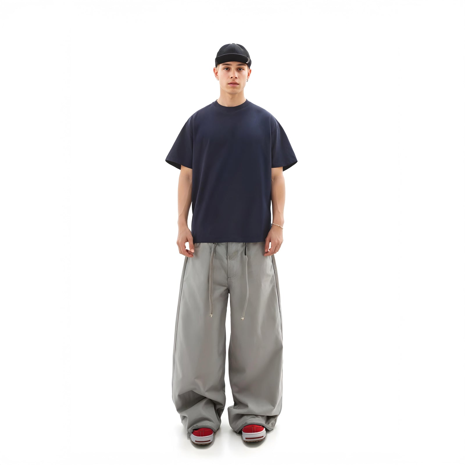 Person wearing a navy t-shirt and gray pants on a white background