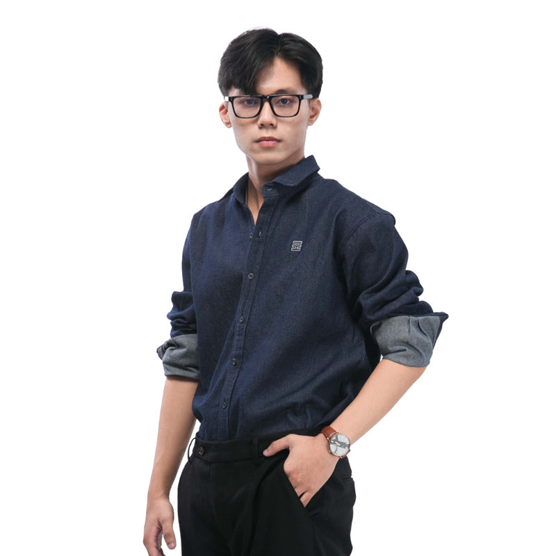 Man wearing a navy blue shirt with rolled-up sleeves on a white background