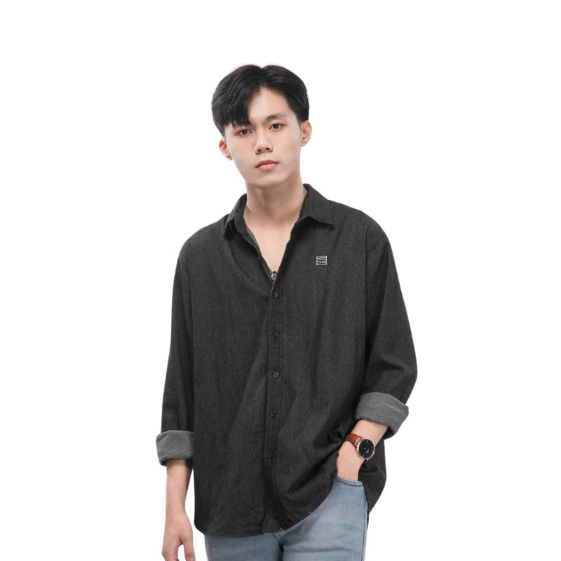 Person wearing a dark gray button-up shirt with rolled-up sleeves on a white background