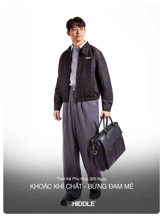 Man holding a briefcase wearing a gray outfit with 'Hiddle' branding.