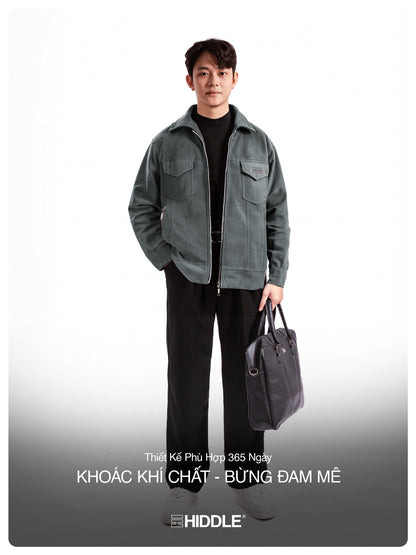 Man wearing a gray jacket holding a bag on a white background with Hiddle branding.