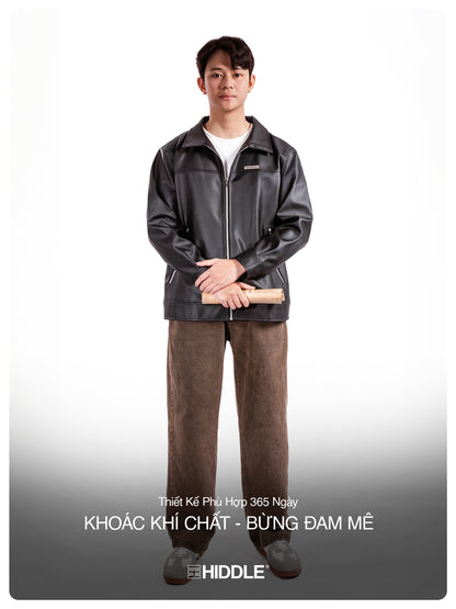 Man wearing a black leather jacket and brown pants on a white background with text.