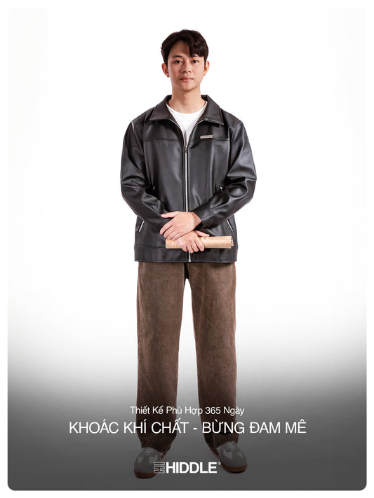 Man wearing a black leather jacket and brown pants on a white background with text.