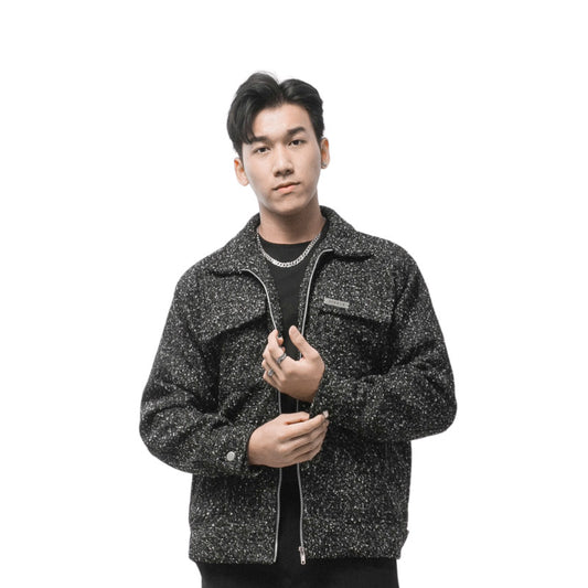 Person wearing a black and gray patterned jacket on a white background