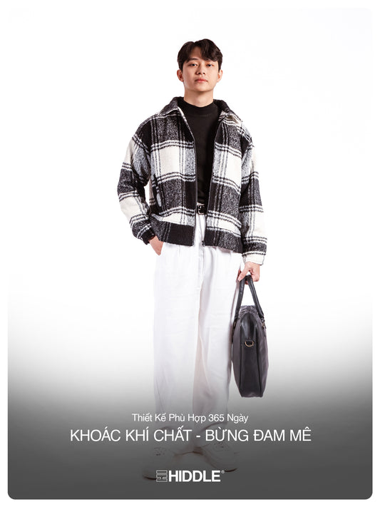 Person wearing a black and white checkered jacket with a gray bag on a white background