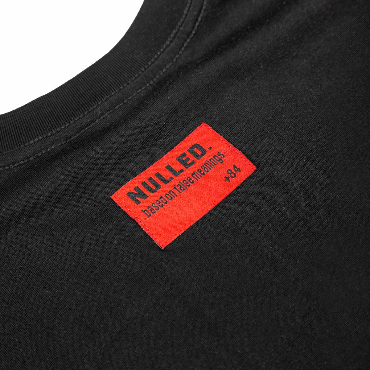 Black t-shirt with a red 'NULLED' label on a white background