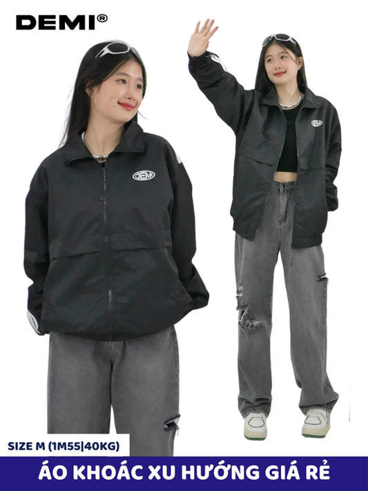Person wearing a black jacket and gray pants with DEMI branding on a white background