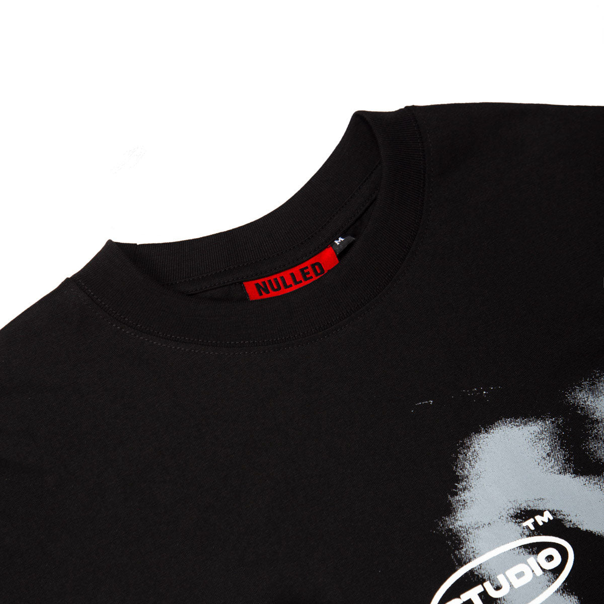 Black t-shirt with a red label and white text on a white background
