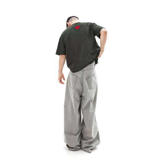 Person wearing a black t-shirt and gray pants on a white background
