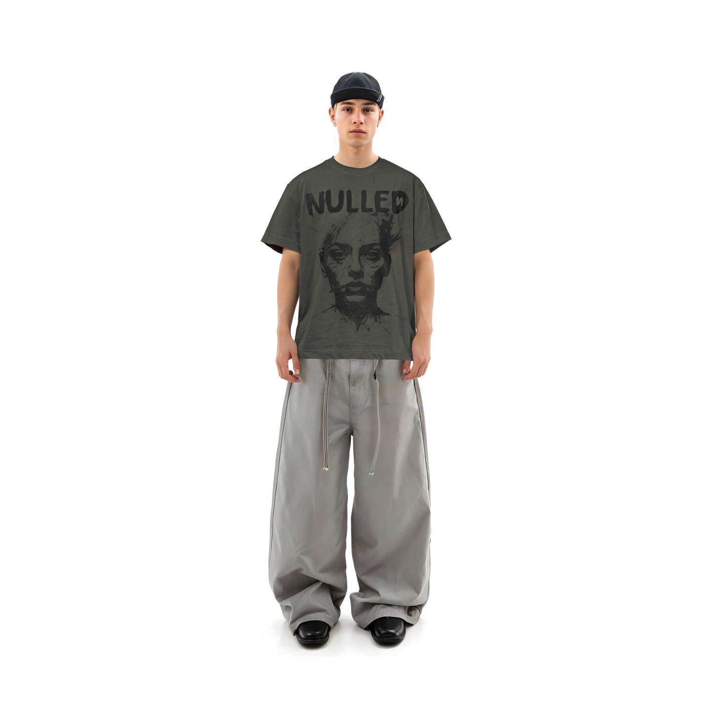 Person wearing a dark gray t-shirt with 'NULLED' text and a graphic design, paired with light gray pants on a white background.