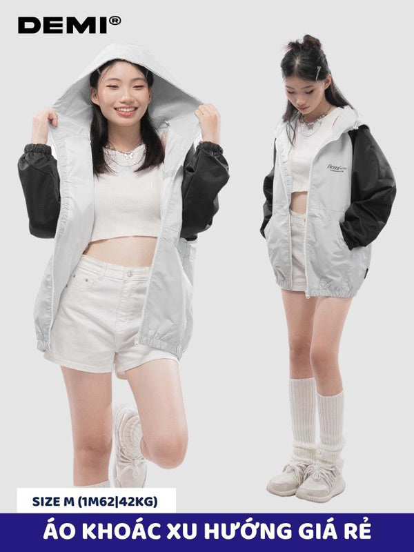 Two women wearing a gray and black jacket with white shorts and sneakers on a light gray background.