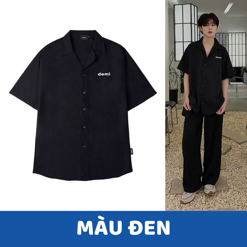 Black shirt with 'demi' logo on a white background, worn by a person indoors.