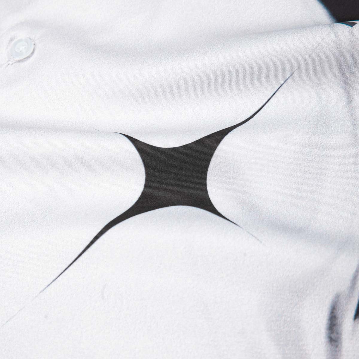 Close-up of a white shirt with a black geometric design on the chest.