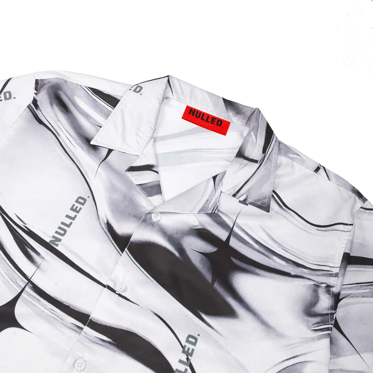 White shirt with black abstract design and 'NULLED' branding on a white background