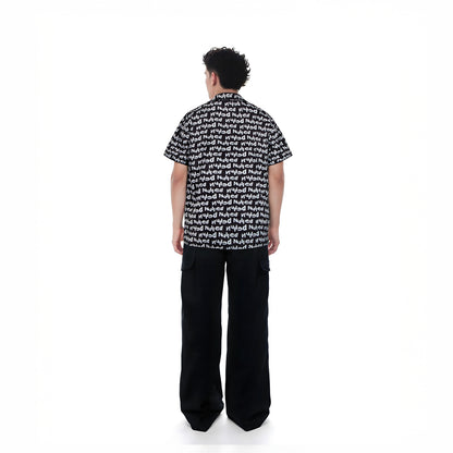 Person wearing a black and white patterned shirt with wide-leg pants on a white background