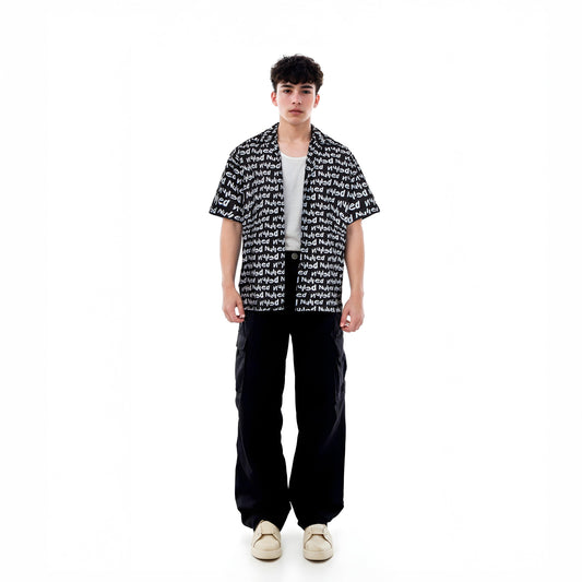 Person wearing a black and white patterned shirt with black pants on a white background