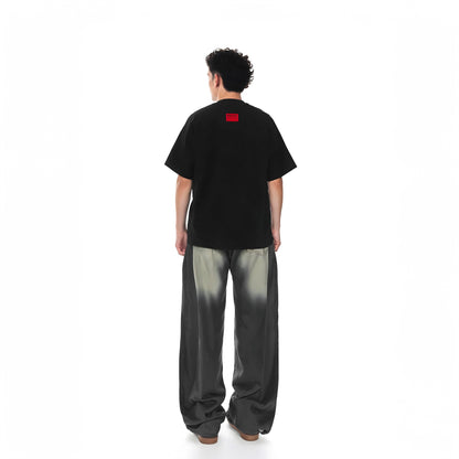 Person wearing a black t-shirt with a red logo on the back, standing against a white background.