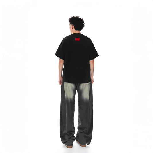 Person wearing a black t-shirt with a red logo on the back, standing against a white background.