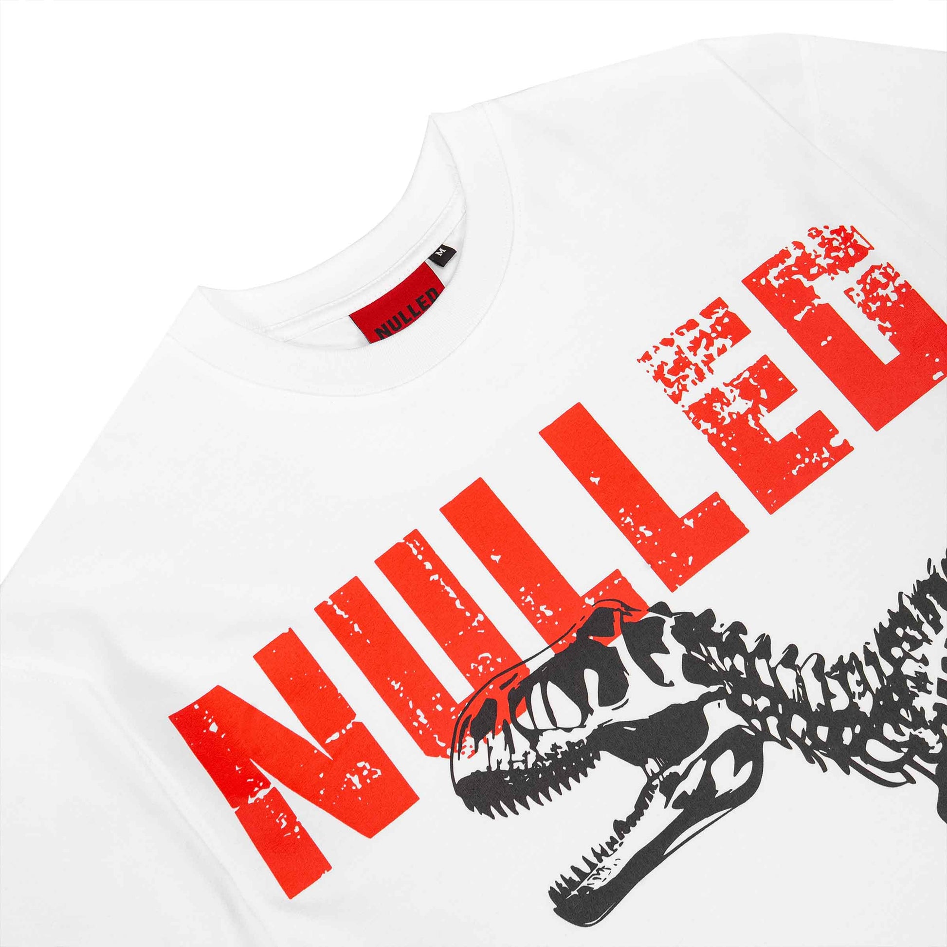 White t-shirt with red 'NULLED' text and black dinosaur skeleton design on a white background