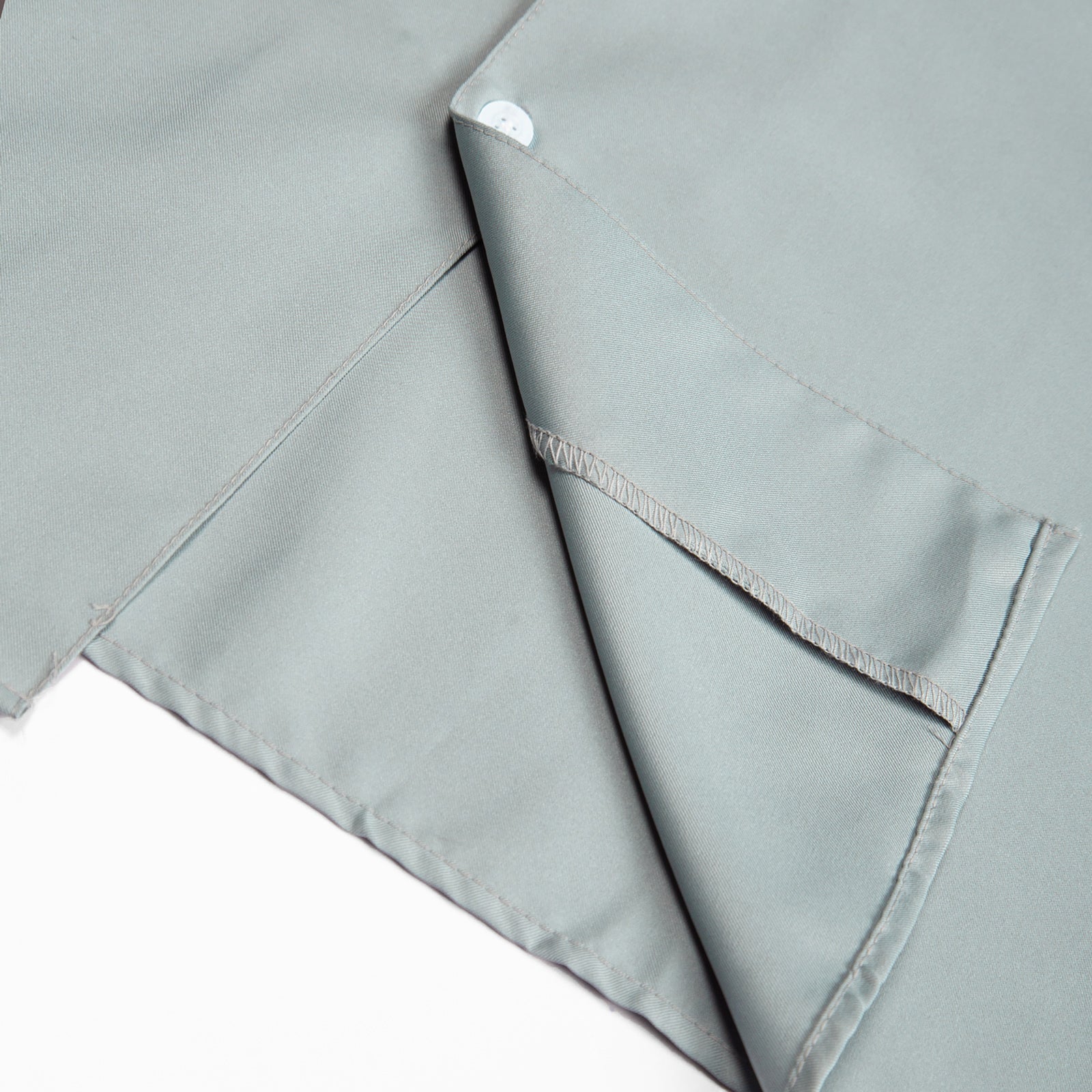 Close-up of light gray fabric with a subtle pattern on a white background