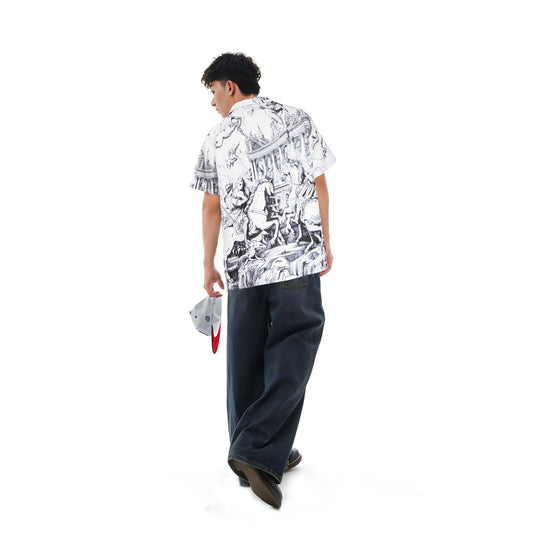 Person wearing a white shirt with black patterns and dark pants on a white background