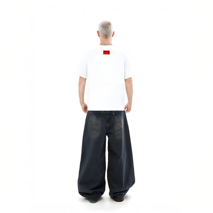 Person wearing a white t-shirt with a red logo and dark blue wide-leg pants on a white background