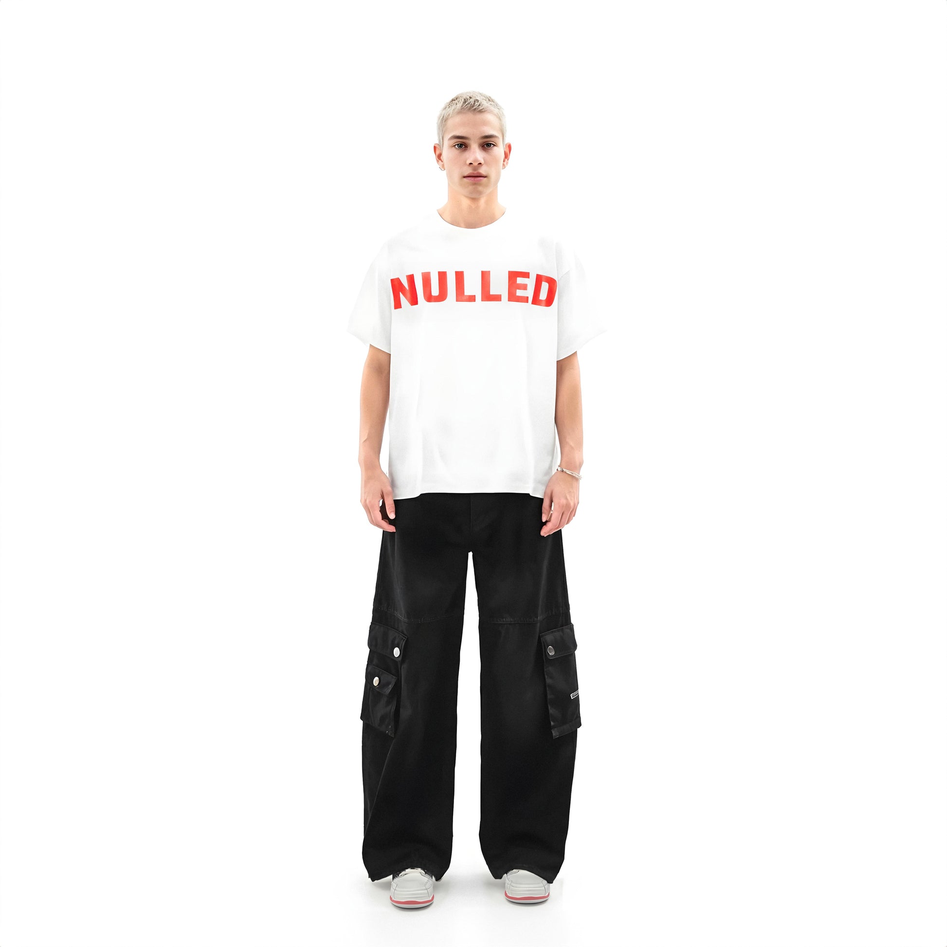 Person wearing a white t-shirt with 'NULLED' printed in red on a white background