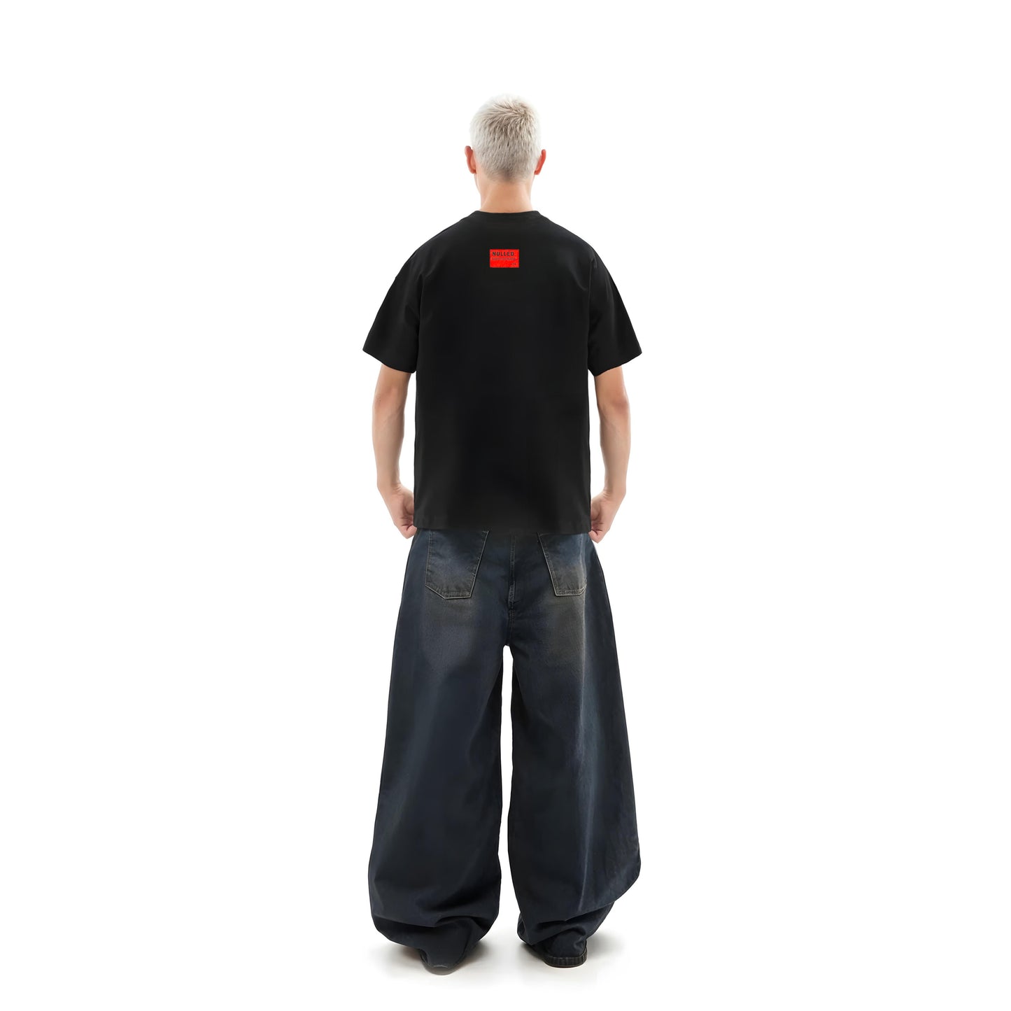 Person wearing a black t-shirt with a red logo on the back, standing against a white background.