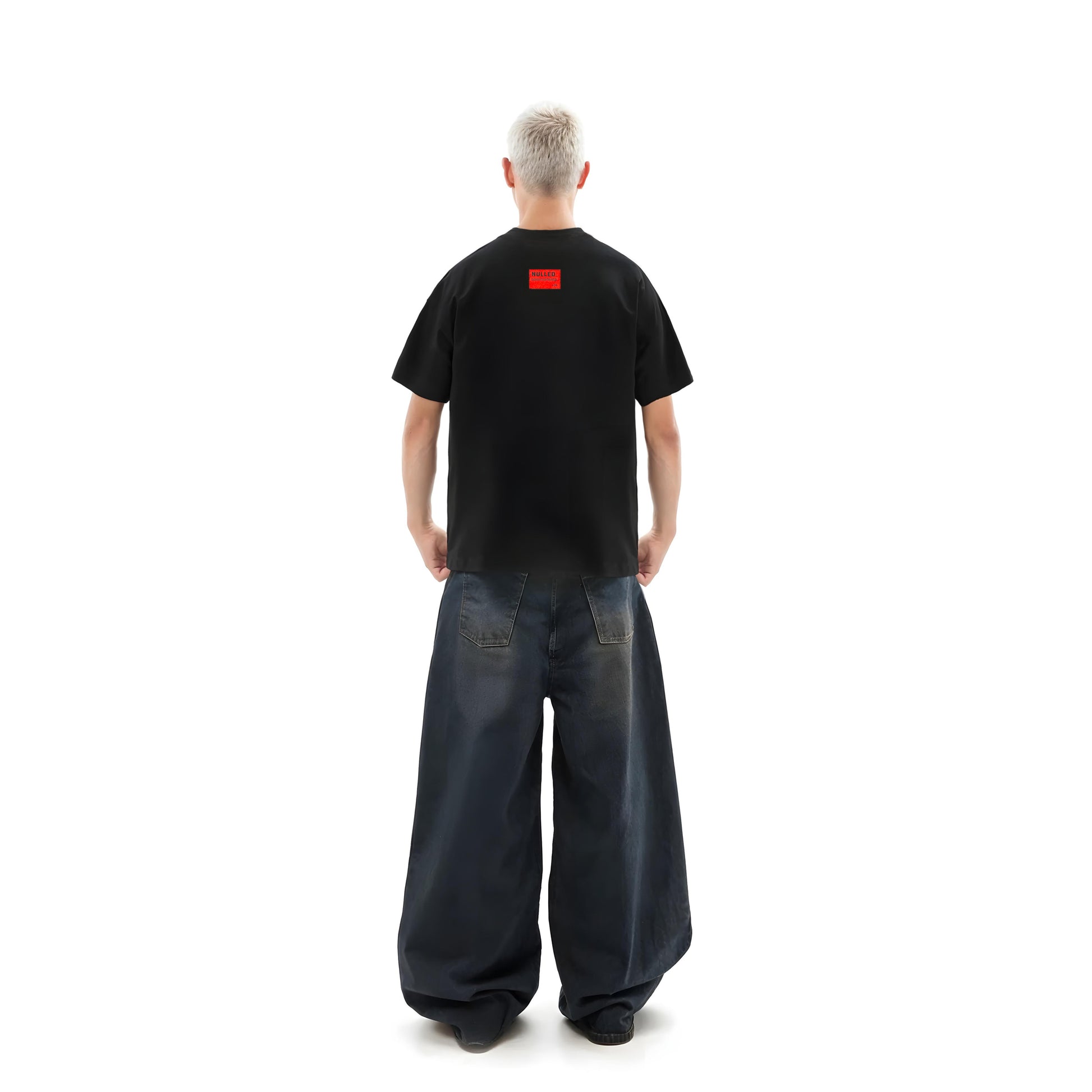 Person wearing a black t-shirt with a red logo on the back, standing against a white background.