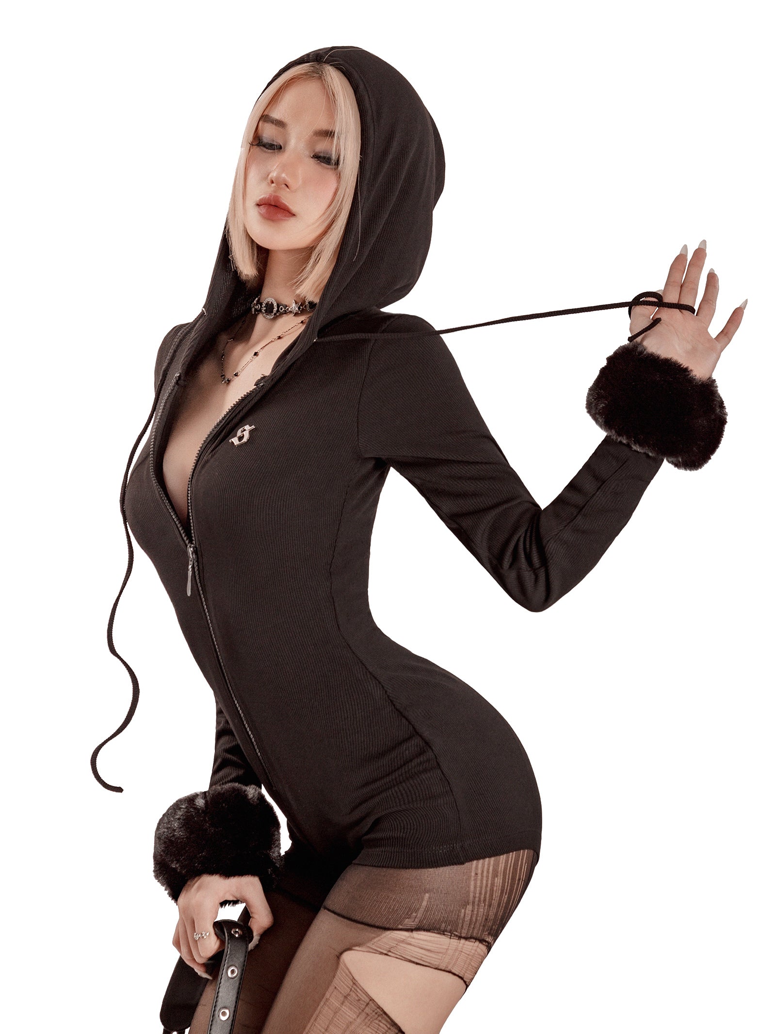 Person wearing a black hooded outfit with fur cuffs on a white background
