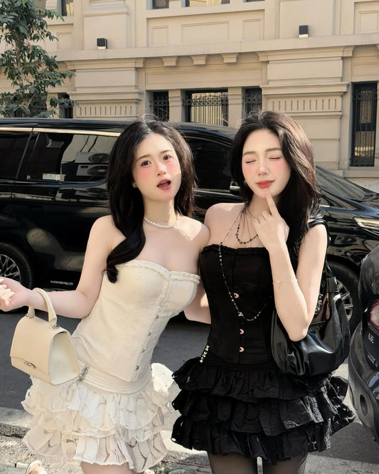 Two women posing outdoors with a black limousine in the background