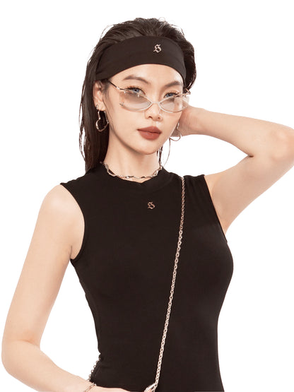 Woman wearing a black sleeveless top and headband with a neutral background