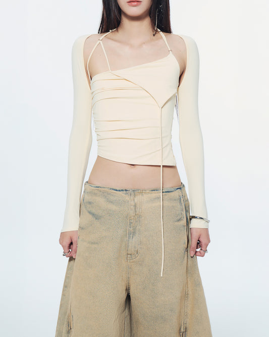 Person wearing a beige crop top and wide-leg pants on a white background