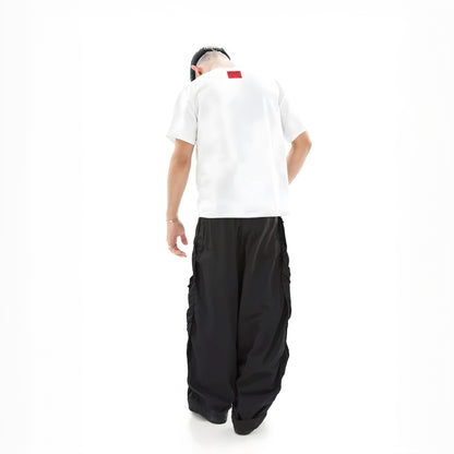 Person wearing a white shirt and black pants on a white background