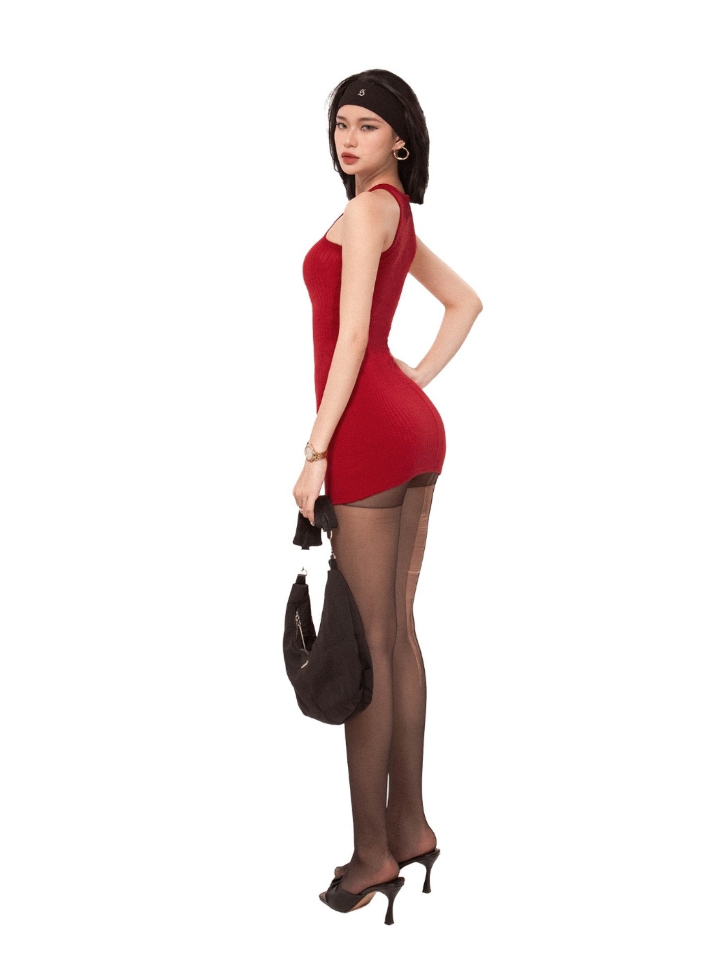 Woman in a red dress and black stockings holding a brown handbag on a white background