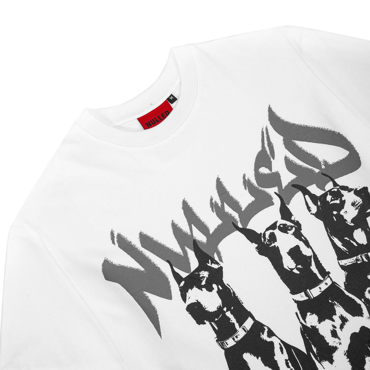 White t-shirt with black graphic of dogs and a red and black label on a white background