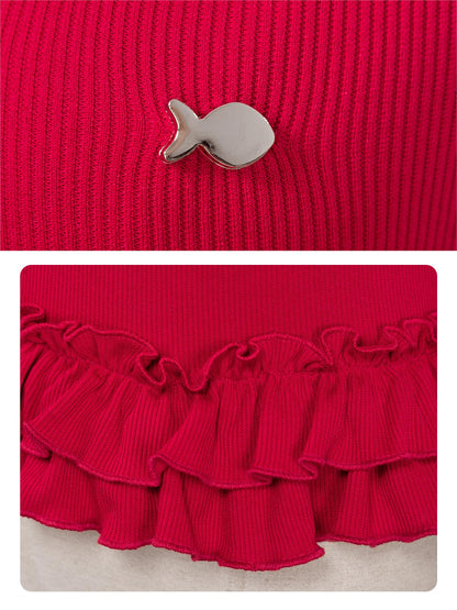 Red knit garment with a small decorative item on a red background