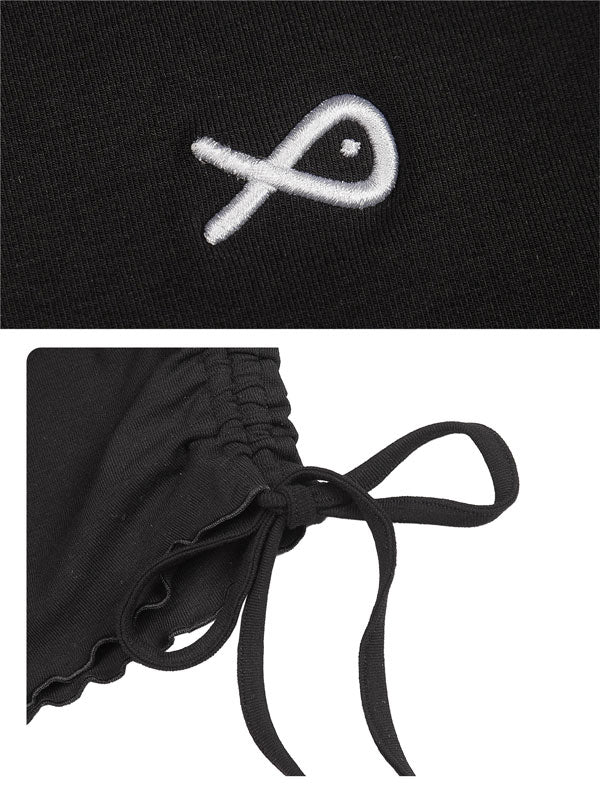 Black garment with a white embroidered symbol and a close-up of a black ribbon detail.
