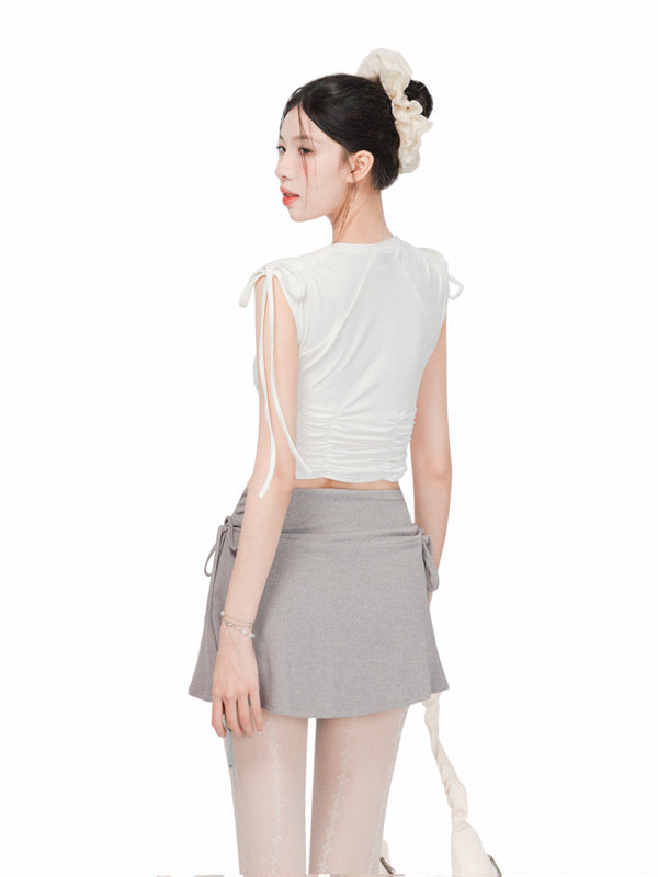 Woman wearing a white top and gray skirt with a white background