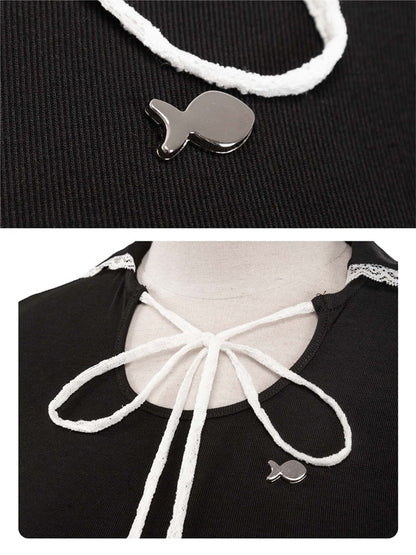 Black top with white lace-up design and silver fish-shaped pendant on a black background