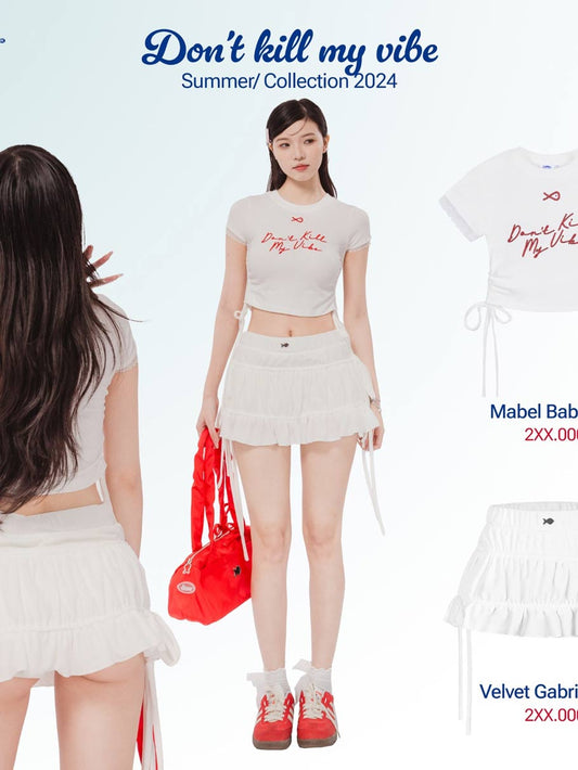 Woman in a white outfit with red accessories, standing against a light blue background with text 'Don't kill my vibe'.