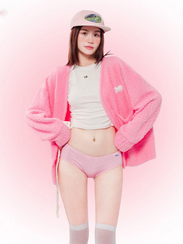 Person wearing a pink outfit with a matching hat on a pink background
