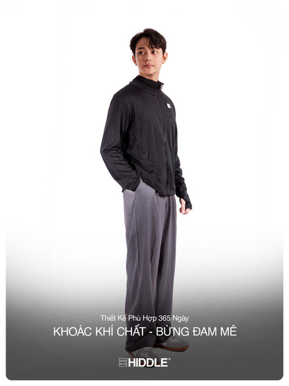 Man wearing a black jacket and gray pants with 'Hiddle' branding on a white background