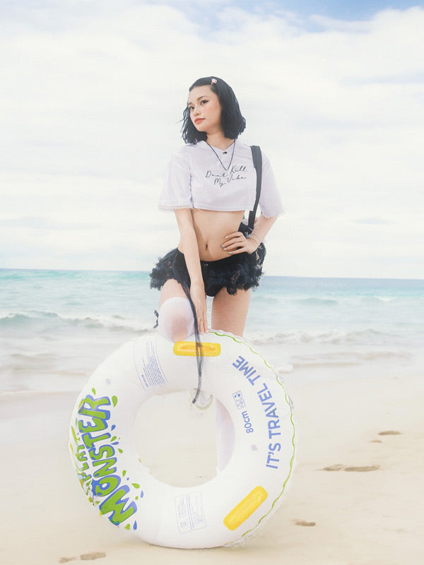 Woman holding a inflatable ring on a beach with ocean and sky in the background