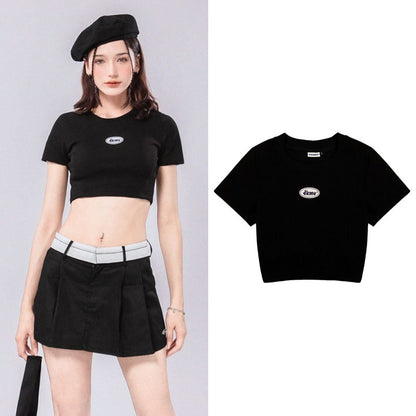 Woman wearing a black crop top with a brand logo on a gray background