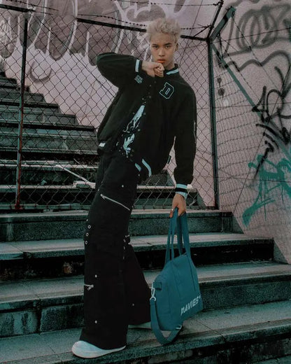 Person in black outfit holding a blue bag on graffiti-covered steps