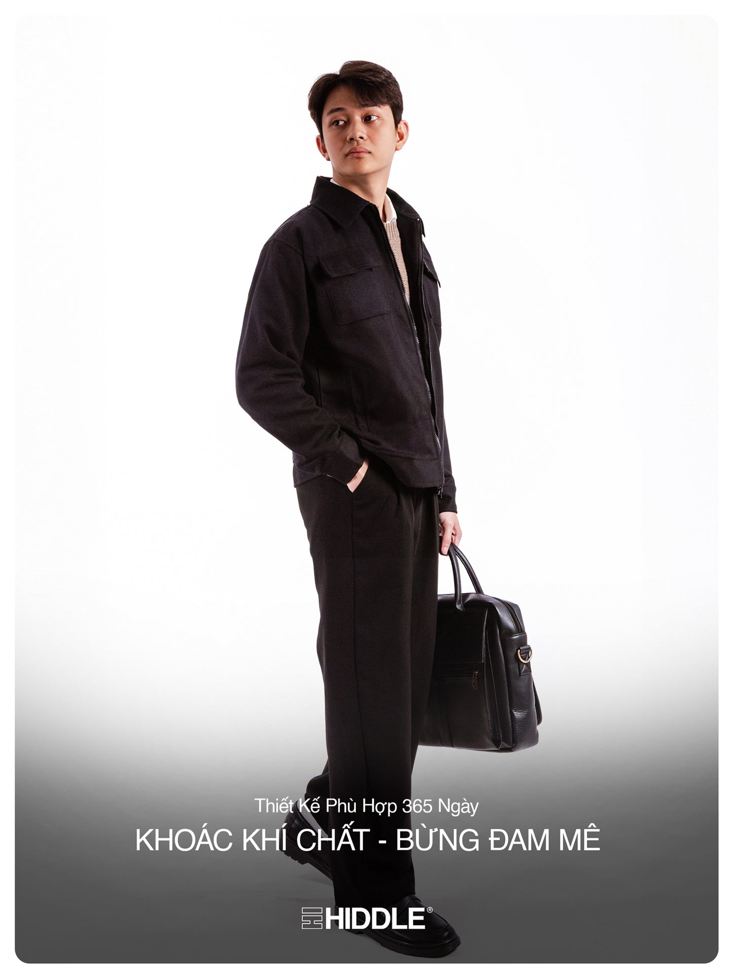 Man in black outfit holding a briefcase with Hiddle branding on a gray background