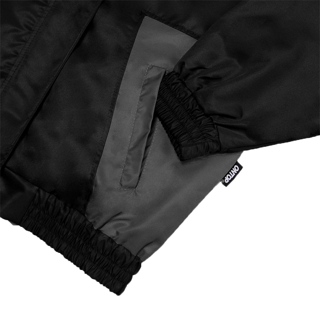 Close-up of black pants with a brand logo on a white background
